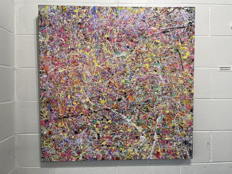 Abstract painting with the main colours red, pink, yellow, white and specks of black