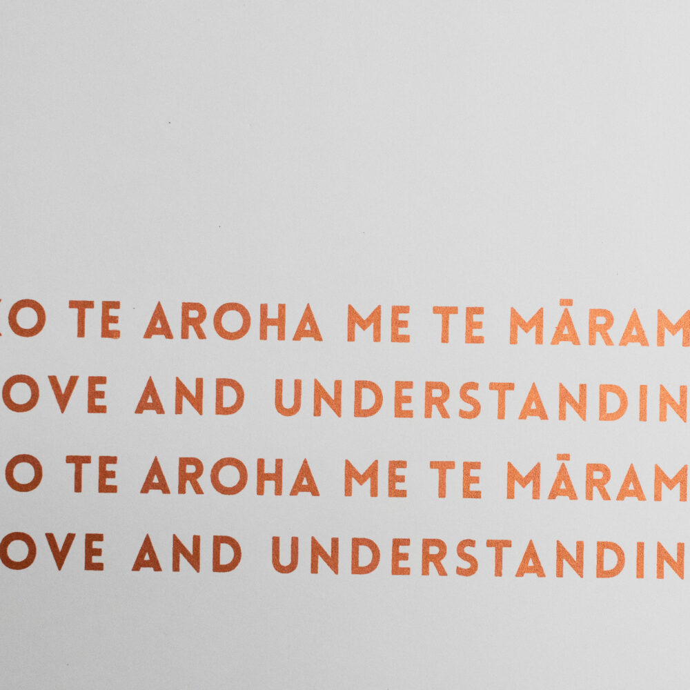 Love and understanding by Ana Ferrari. White background with orange writing. Love and understanding in English and Te Reo repeated twice.